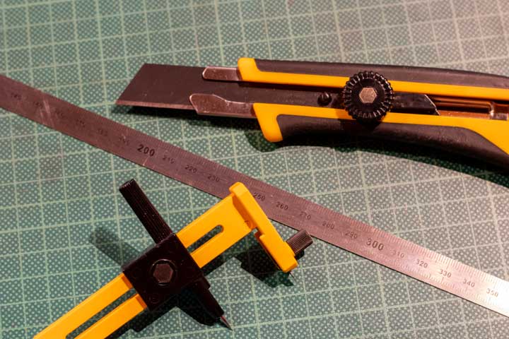 Foto: Cuttermesser,Kreisschneider und Lineal auf grüner Schneidematte.